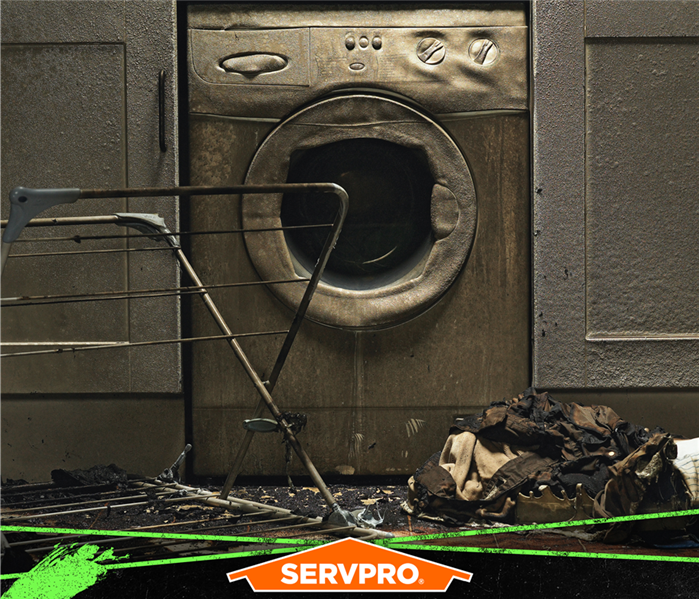 Fire damage to a washing machine, cabinets, with ashes and clothes on the laundry room floor of a home. 